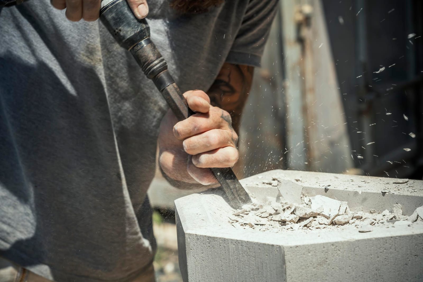 Detalhe de um trabalho de furação e talha em bloco de pedra com ferramenta manual.